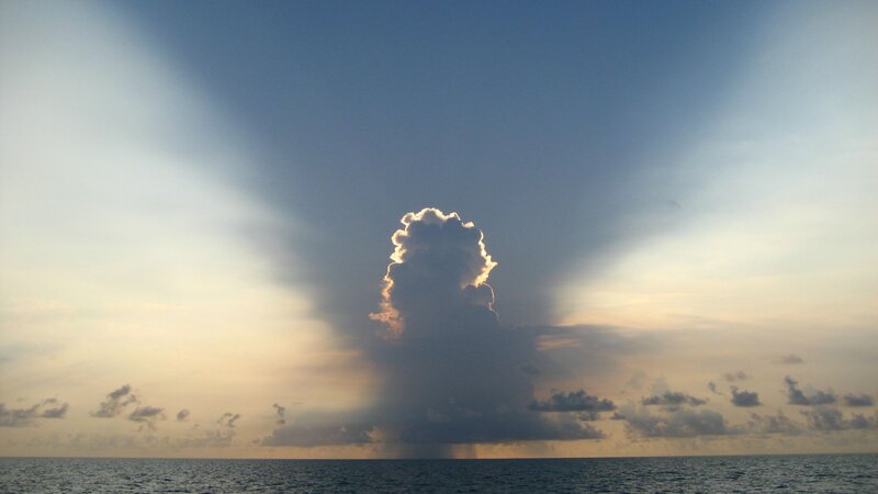 Sunlight beams over ocean cloud