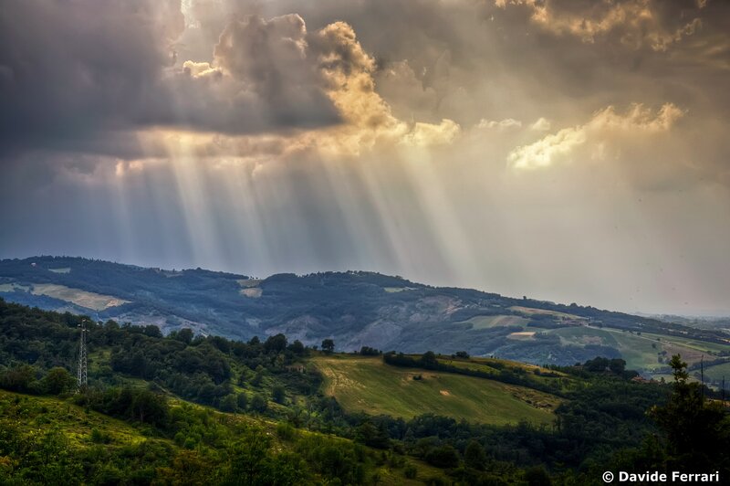 Sunlight beams over rolling hills