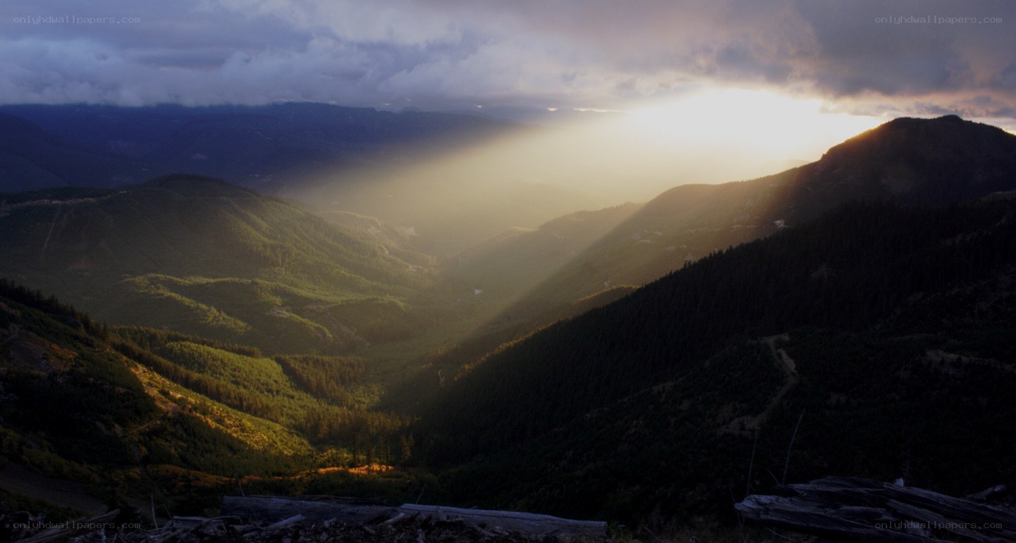Sunlight beams through mountain clouds