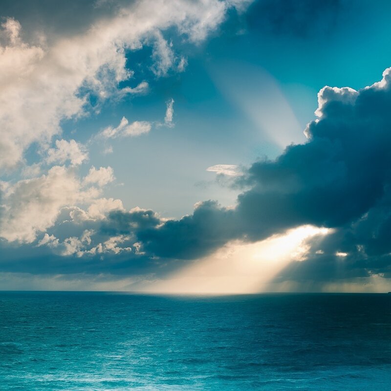 Sunlight breaking through clouds over ocean