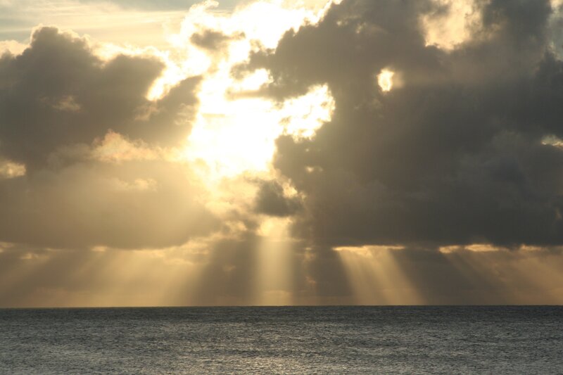 Sunlight breaking through clouds over ocean