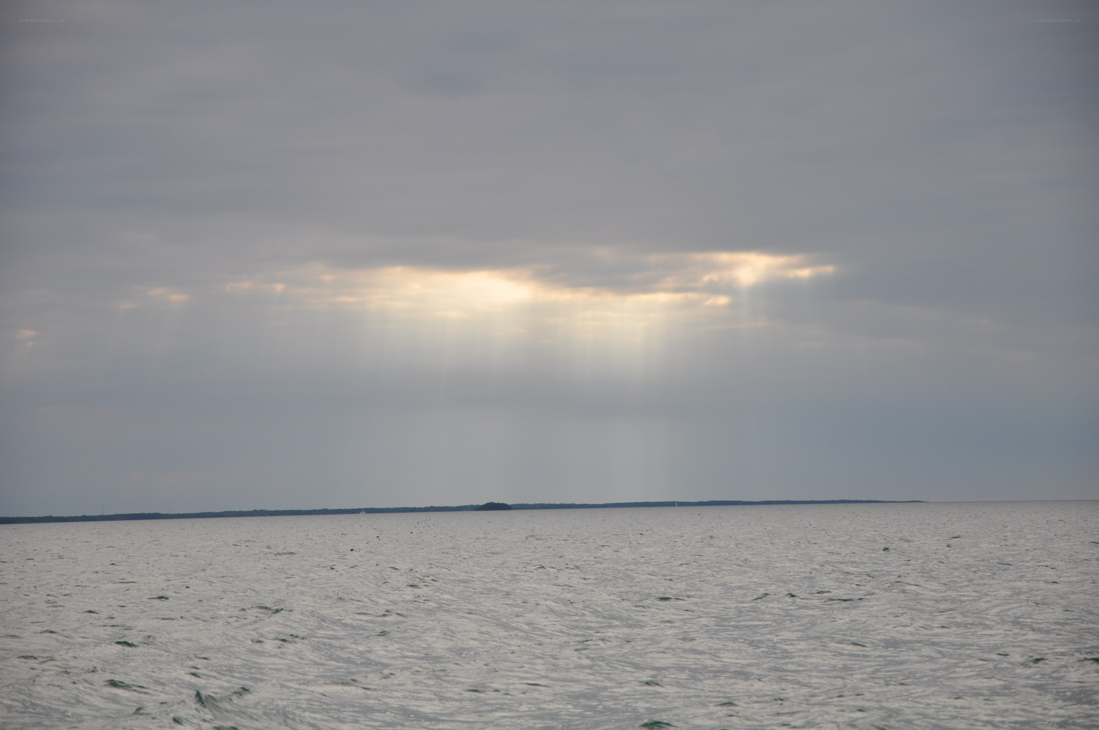Sunlight breaking through clouds over water