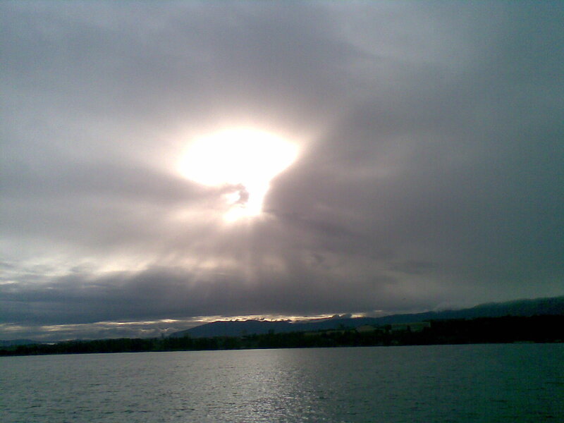 Sunlight breaking through clouds over water