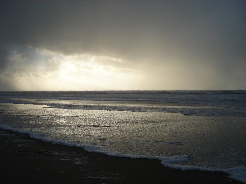 Sunlight breaking through storm clouds at beach