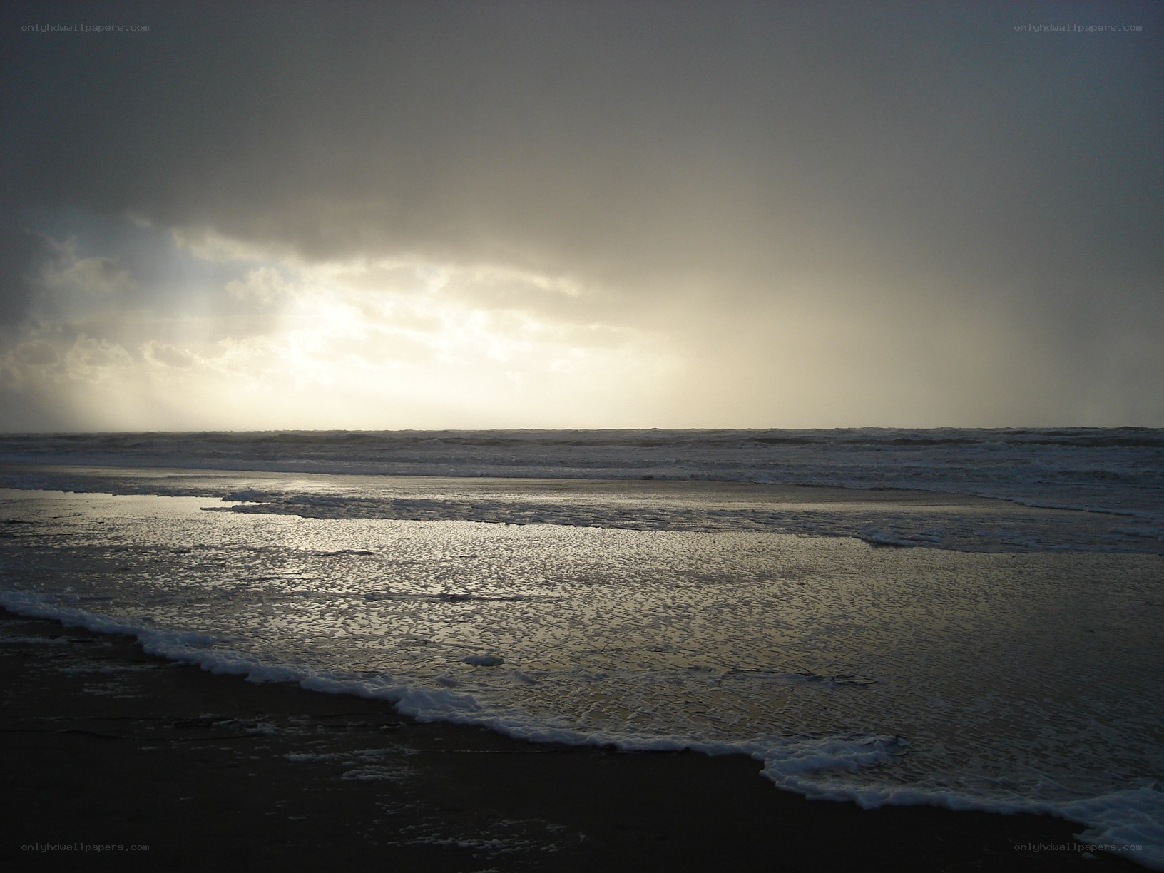 Sunlight breaking through storm clouds at beach