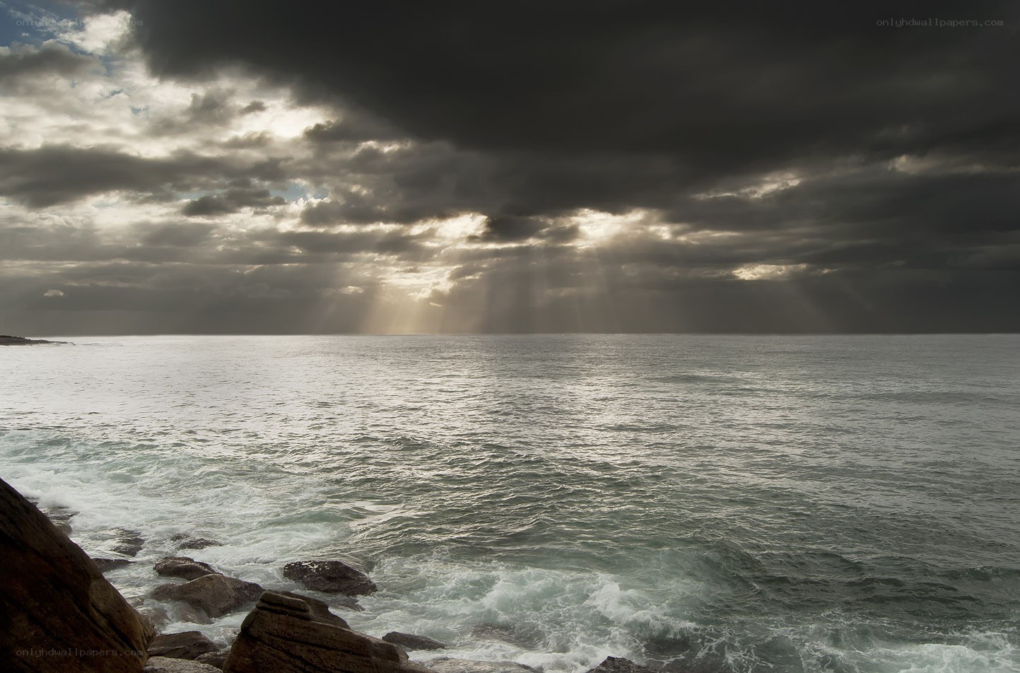 Sunlight breaking through storm clouds over the sea