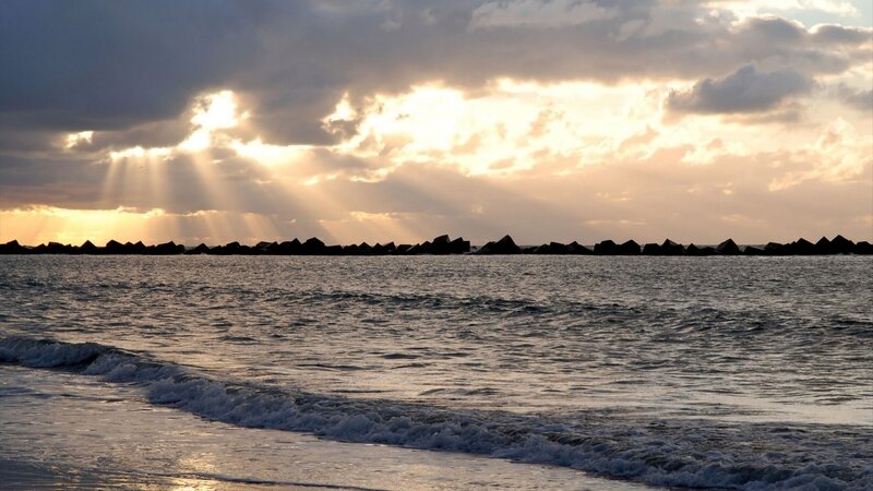 Sunlight breaks through clouds over sea