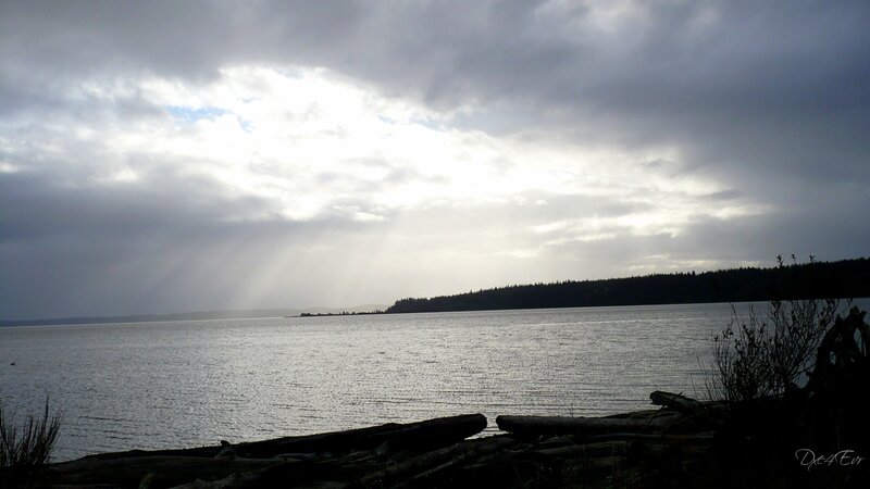 Sunlight breaks through clouds over water