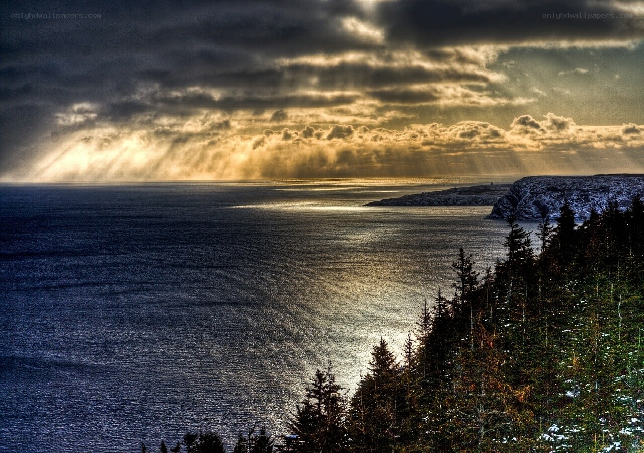 Sunlight breaks through storm clouds over sea
