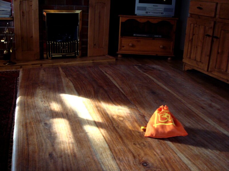 Sunlight on wooden floor with orange bag
