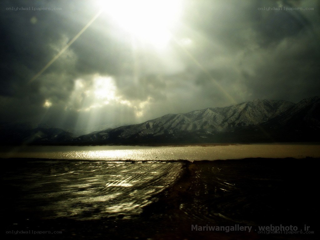 Sunlight over a lake and mountains