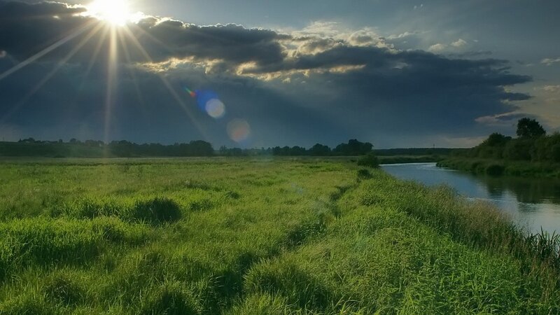 Sunlight over a river and field