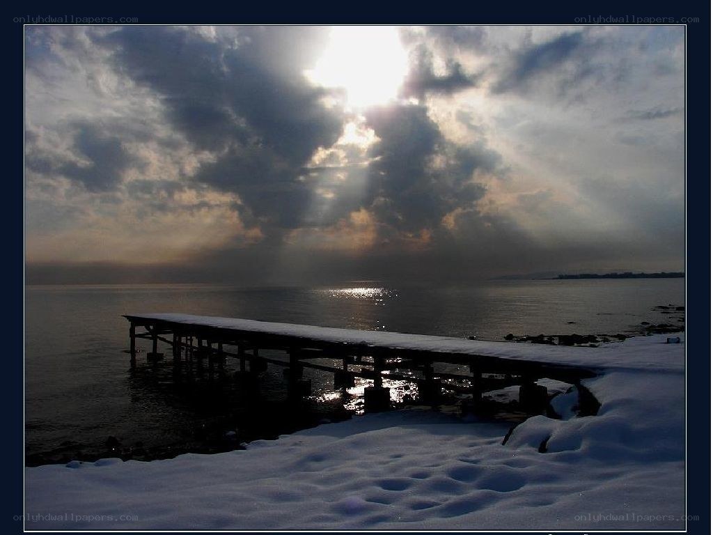 Sunlight over a snowy dock