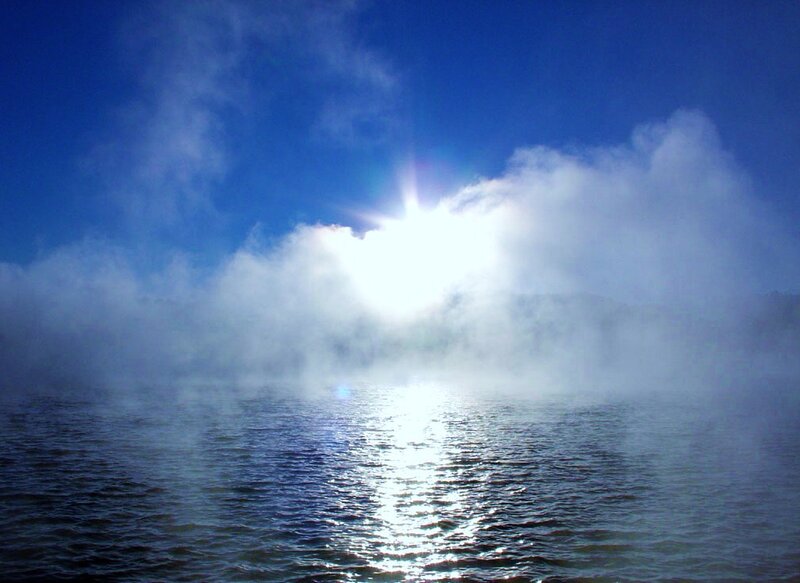 Sunlight over misty lake