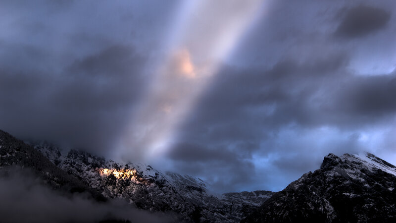 Sunlight piercing mountain clouds