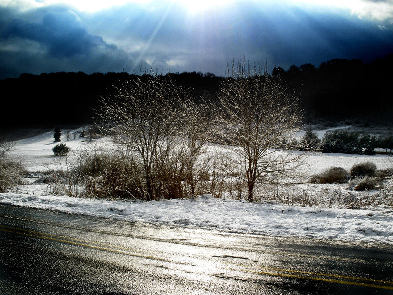 Sunlight through clouds on snowy road