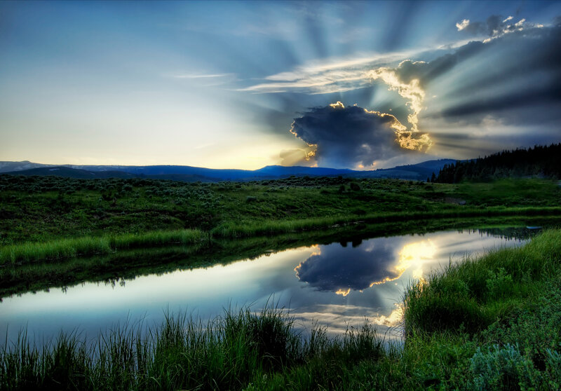 Sunlight through clouds over a pond