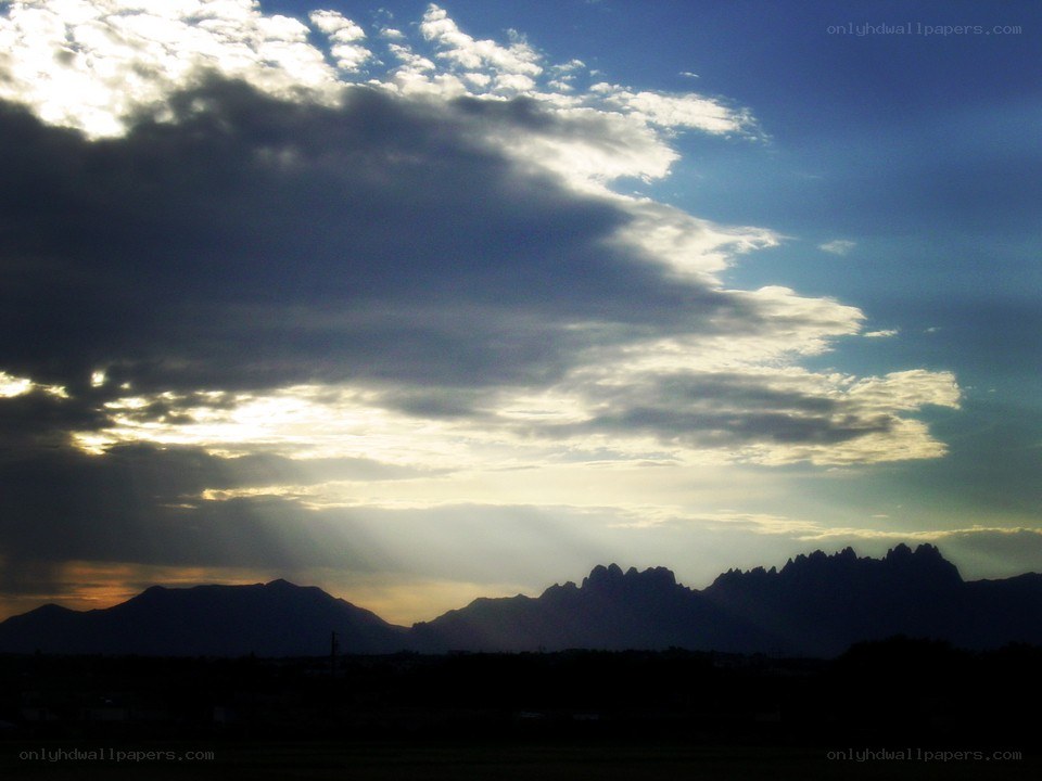 Sunlight through clouds over mountains