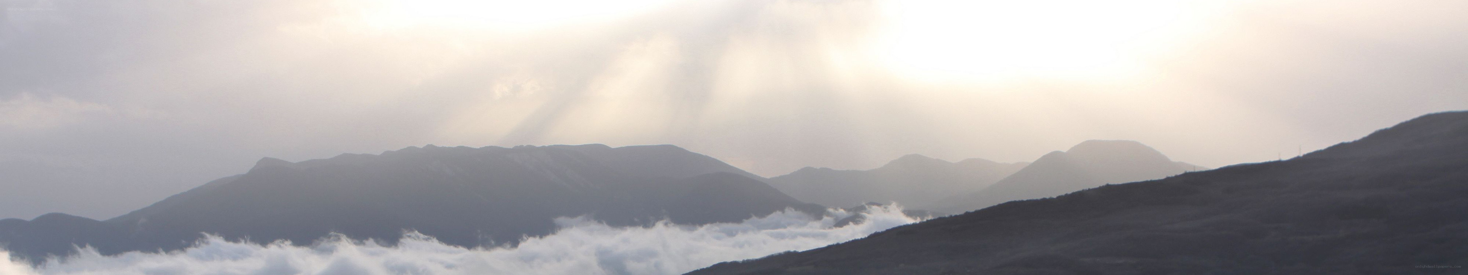 Sunlight through clouds over mountains