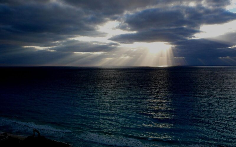 Sunlight Through Clouds over Ocean — Blue, Dramatic, Sunrise