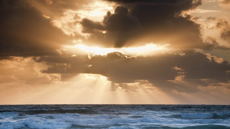 Sunlight Through Clouds over Ocean — Gold