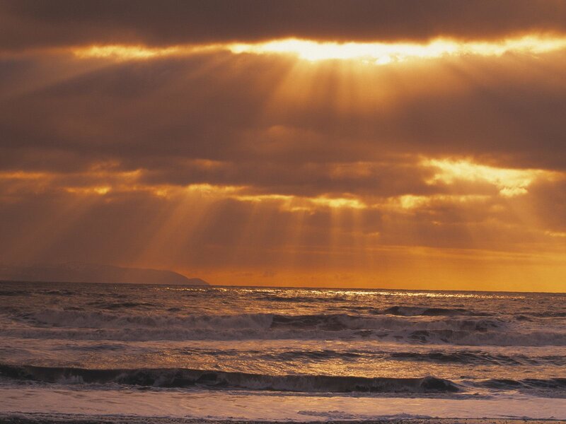 Sunlight Through Clouds over Ocean — Orange, Dramatic, Sunset