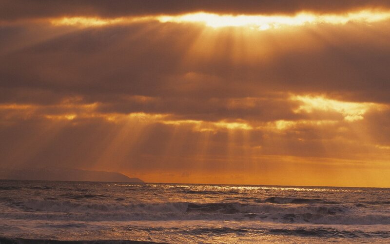 Sunlight through clouds over ocean