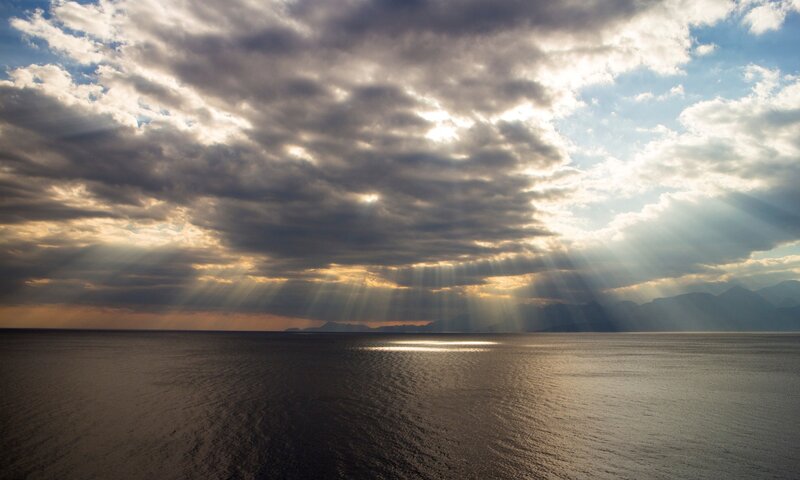 Sunlight Through Clouds over Sea — Blue, Dramatic, Sunset, Photograph