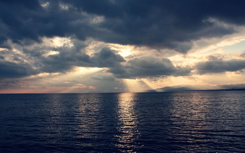 Sunlight Through Clouds over Sea — Blue, Dramatic