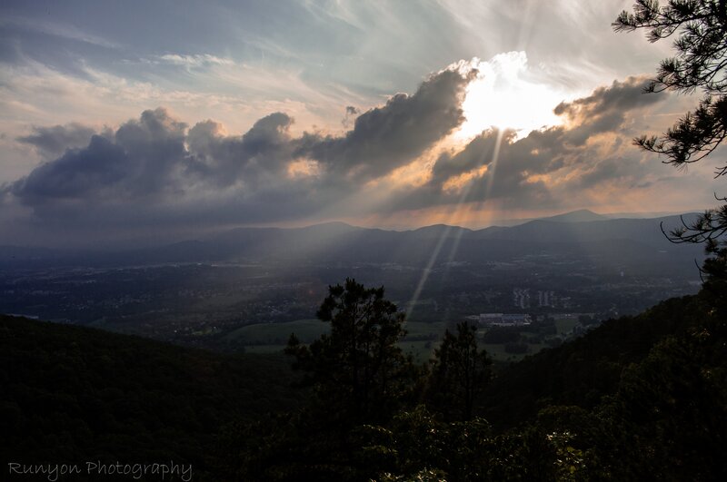 Sunlight through clouds over valley