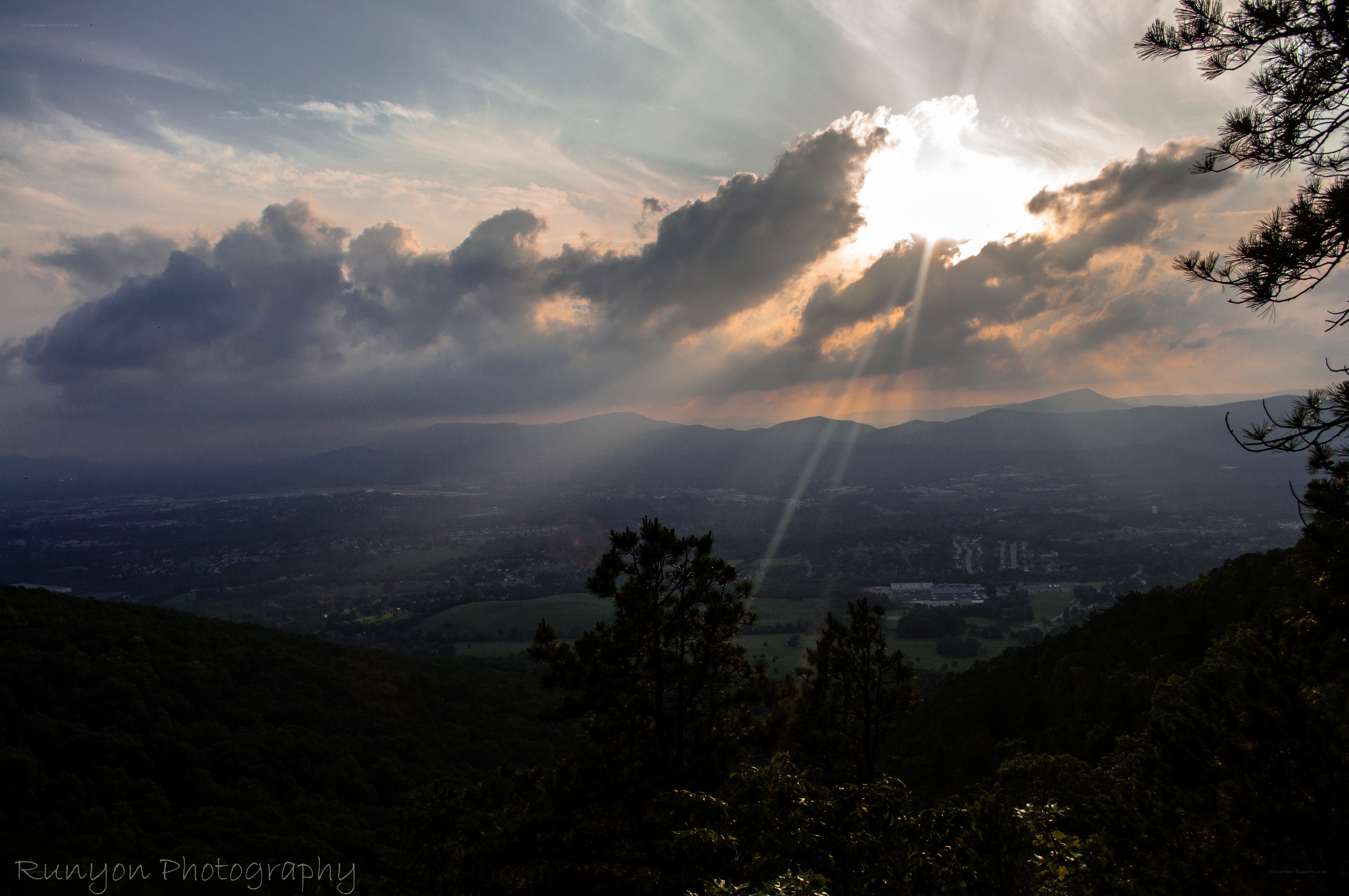 Sunlight through clouds over valley