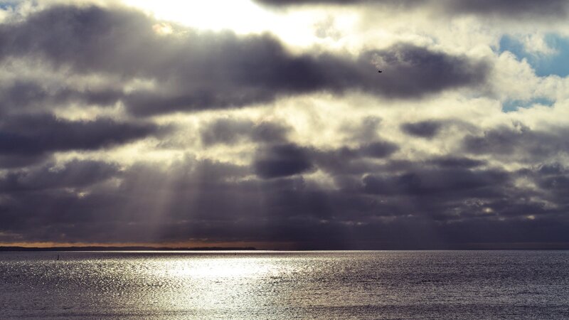 Sunlight Through Clouds over Water — Gray