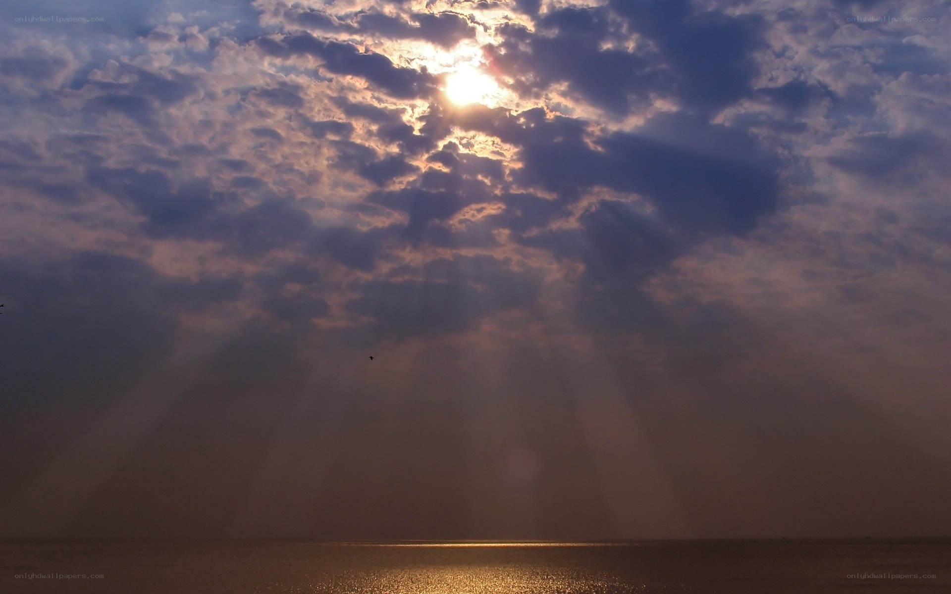 Sunlight through clouds over water
