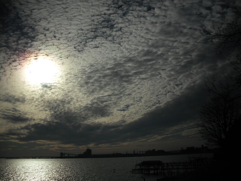 Sunlight through cloudy sky over water