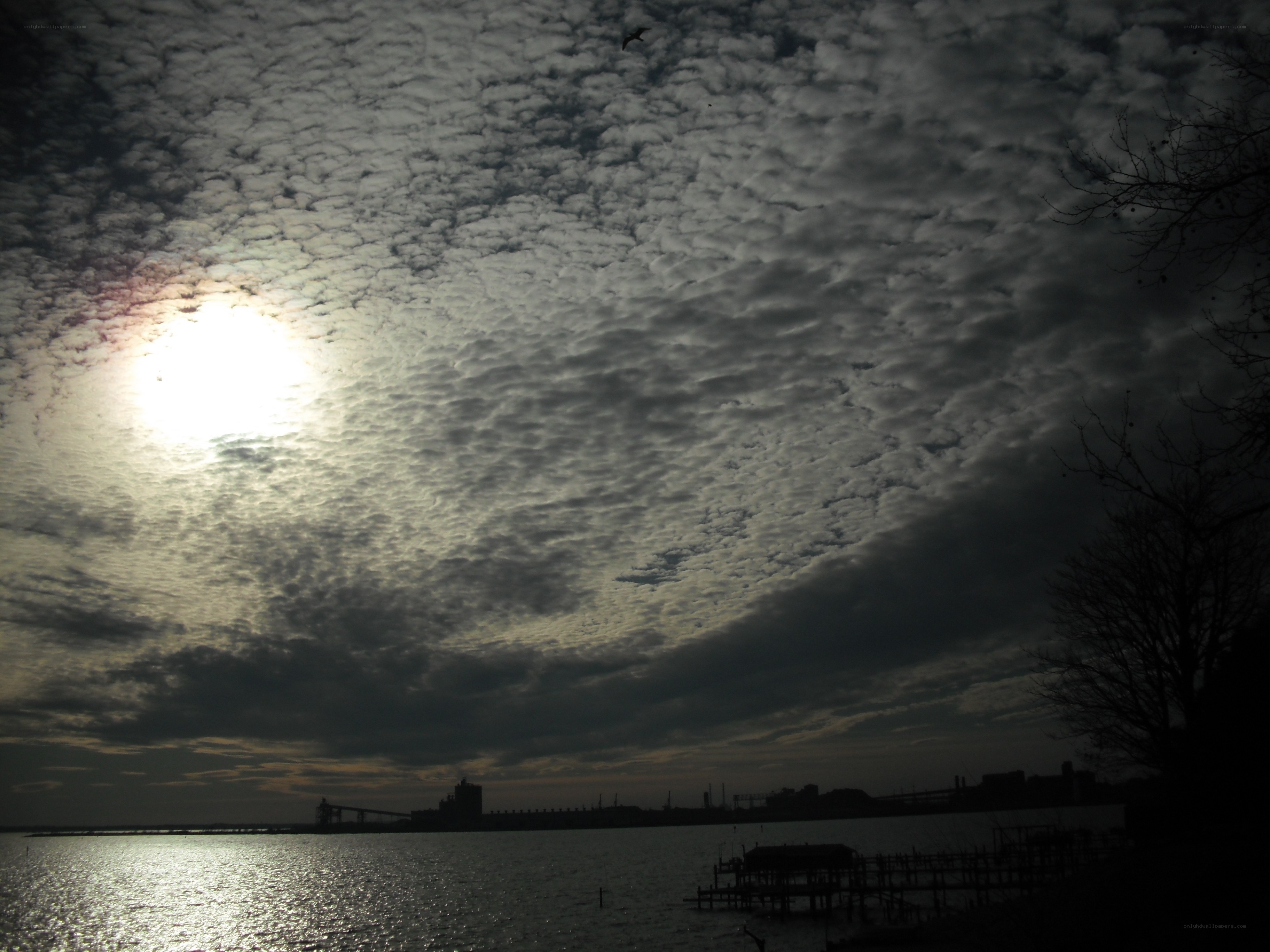 Sunlight through cloudy sky over water