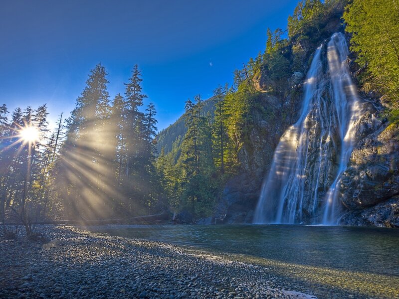 Sunlight through forest waterfall