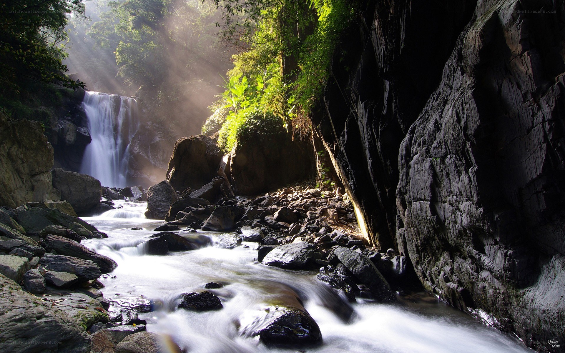 Sunlight through forest waterfall