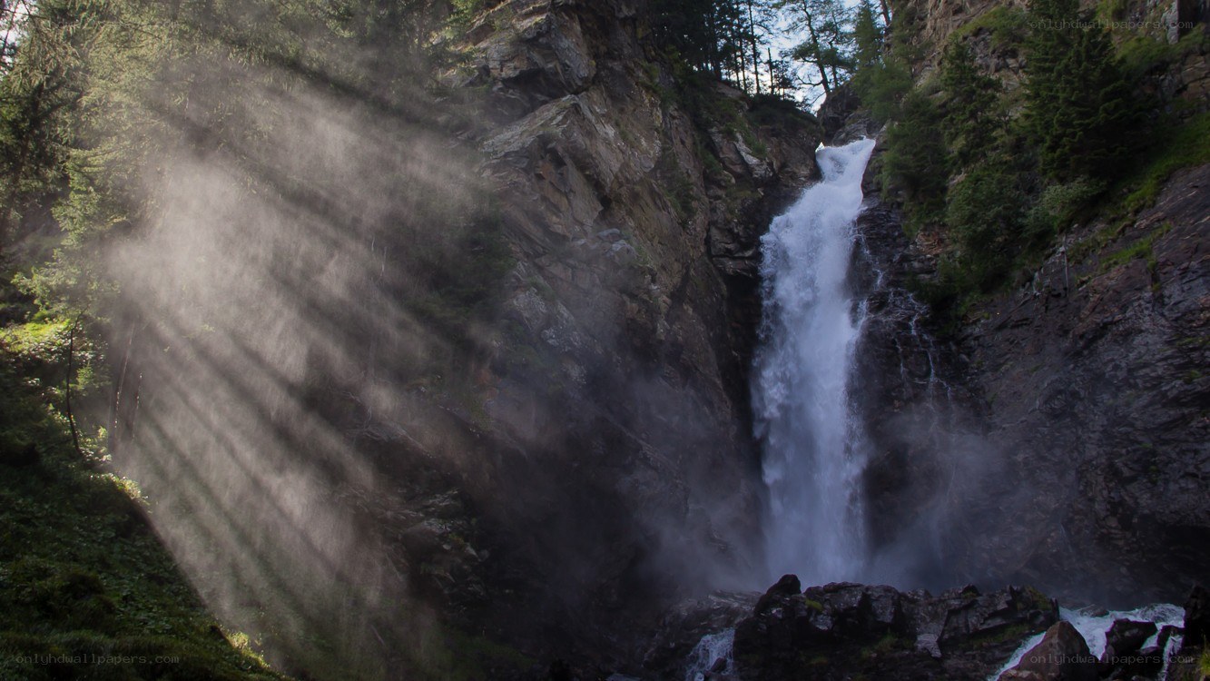 Sunlight through forest waterfall