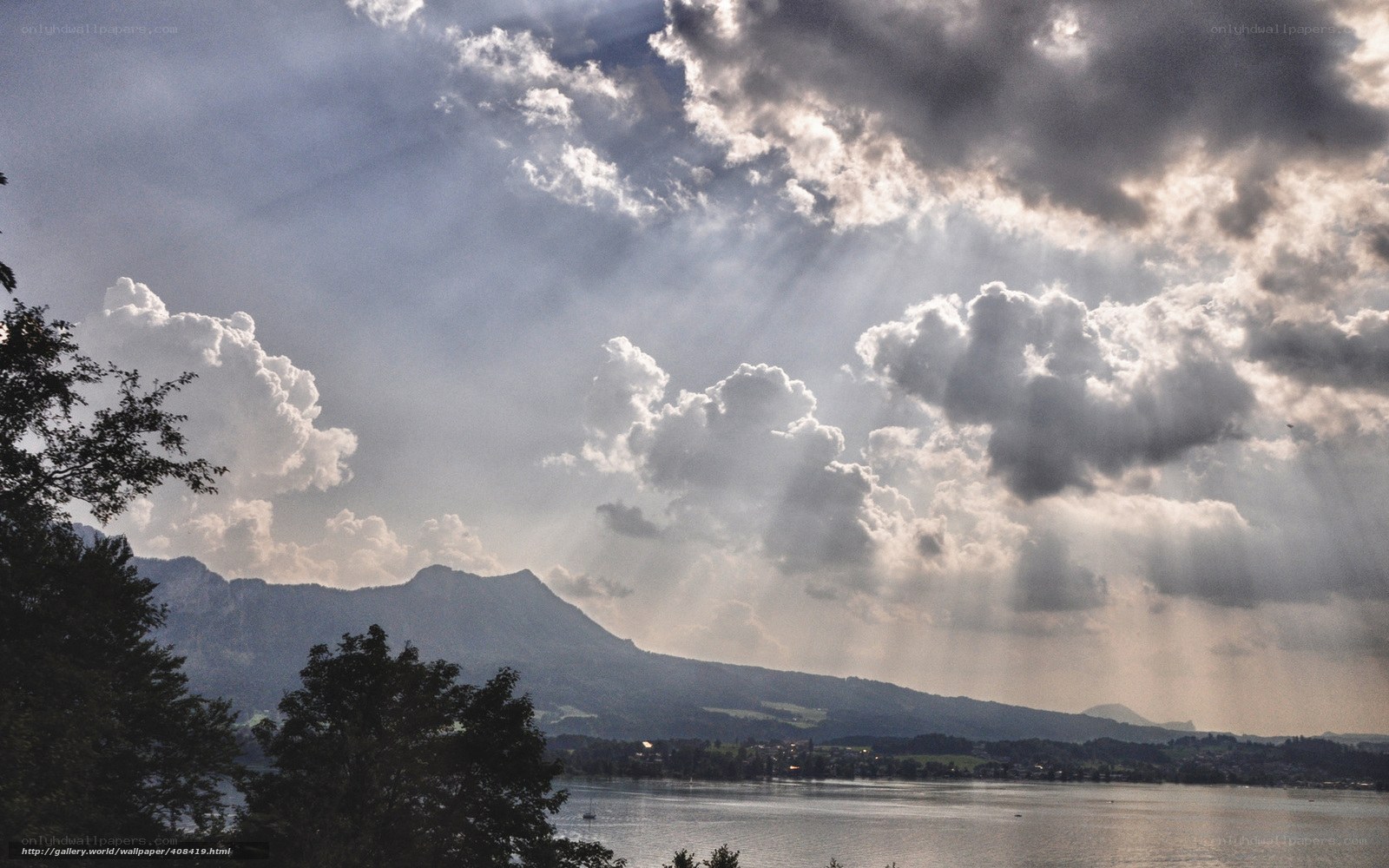 Sunlight through storm clouds over a lake