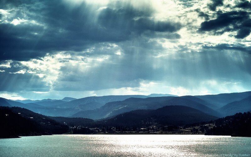 Sunlight through storm clouds over lake