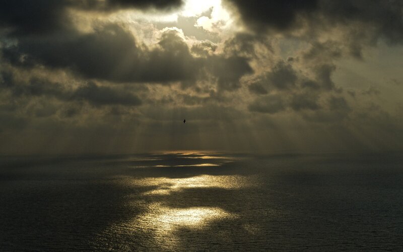 Sunlight through storm clouds over sea
