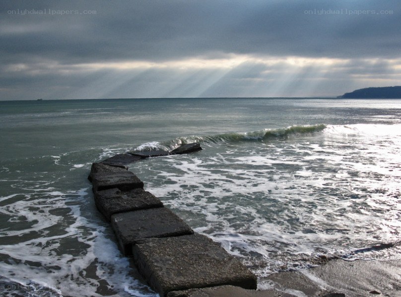 Sunlight through stormy clouds at sea