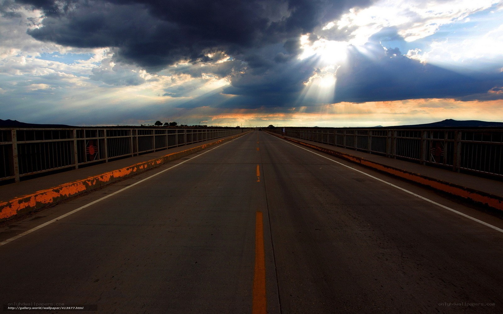 Sunlight through stormy clouds on a bridge