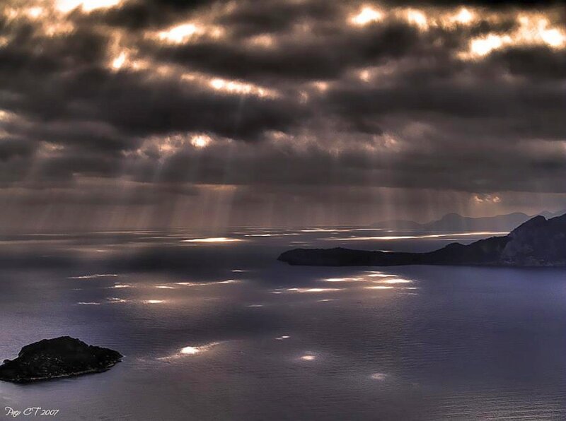 Sunlight through stormy clouds over sea