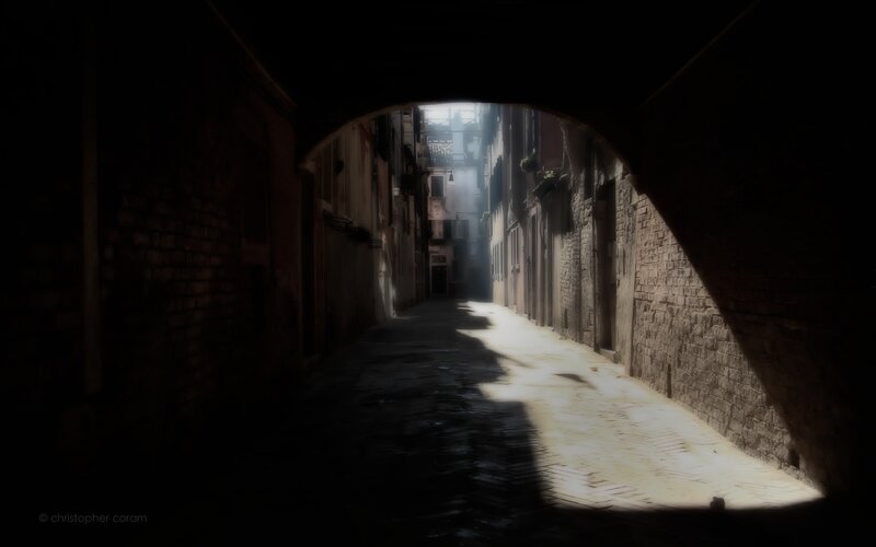 Sunlit alley under archway