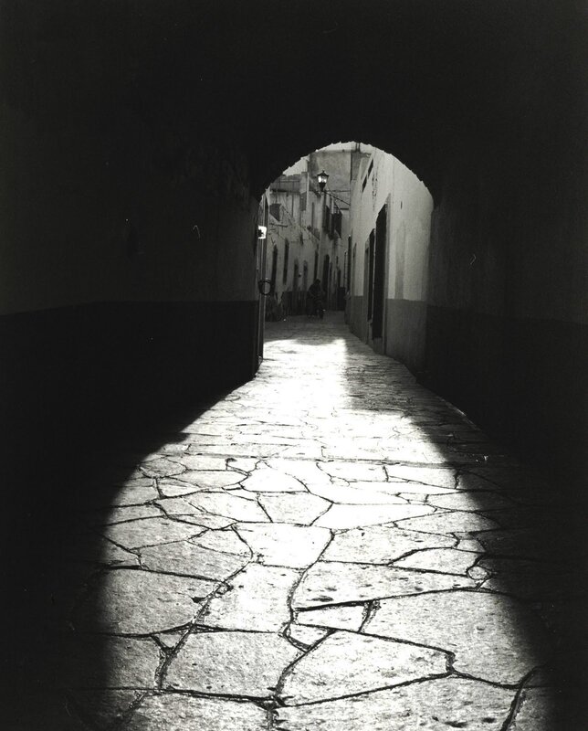 Sunlit alley under archway