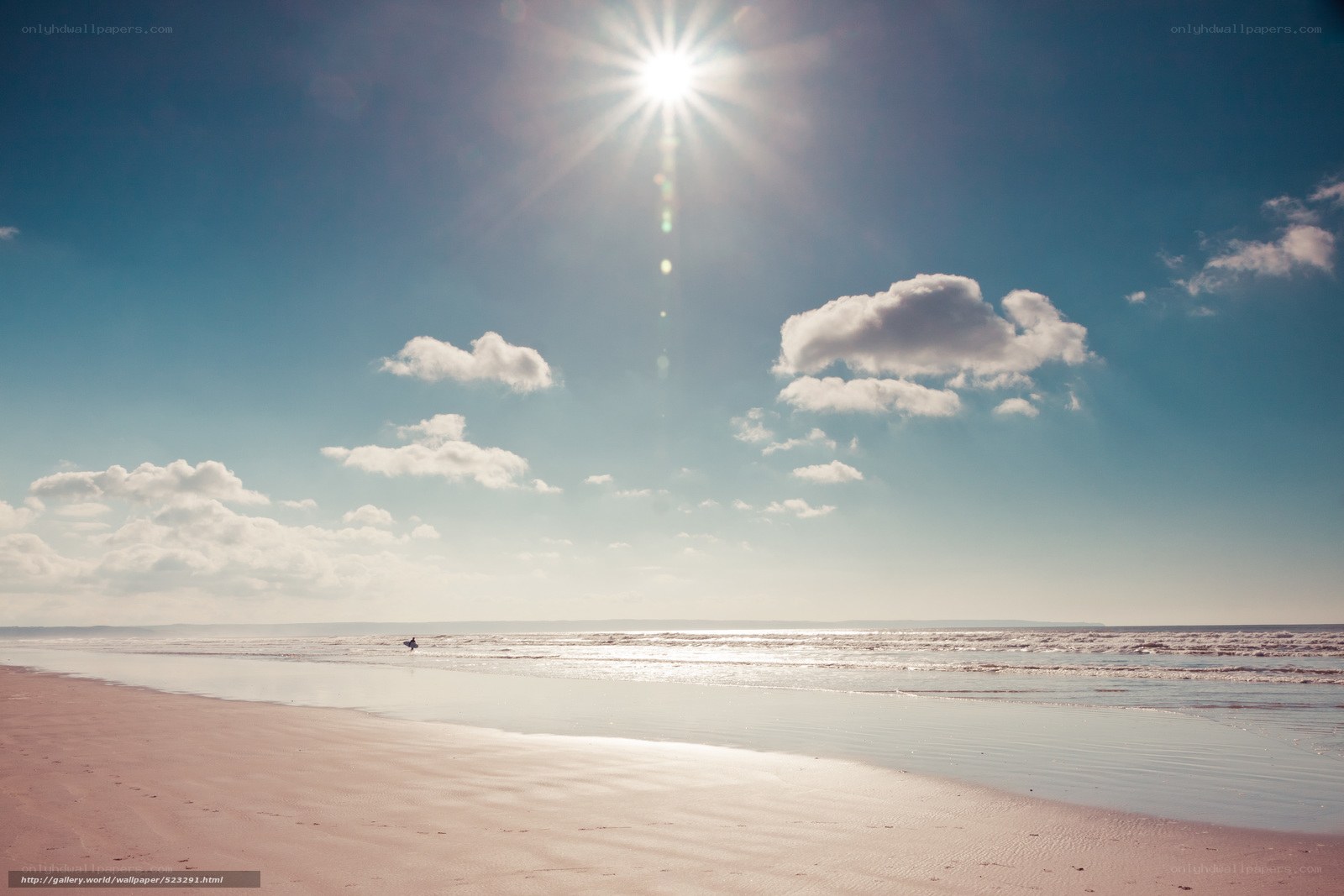 Sunlit beach with surfer