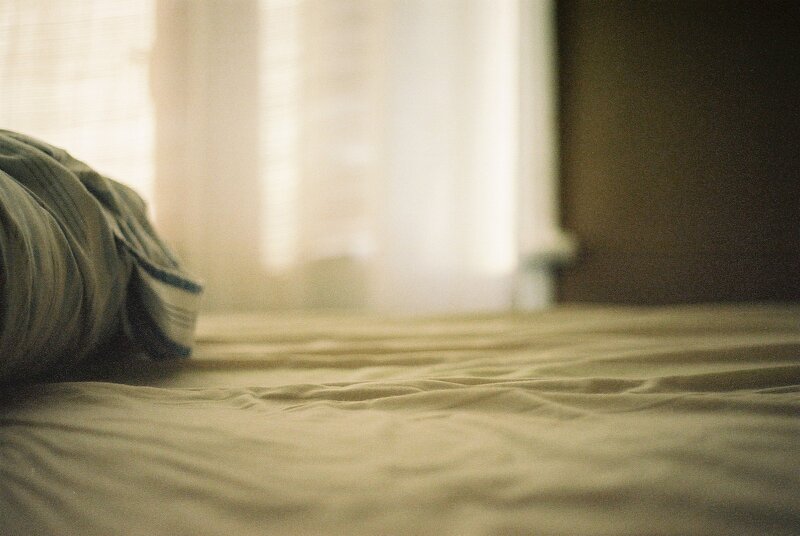 sunlit bed with rumpled sheets