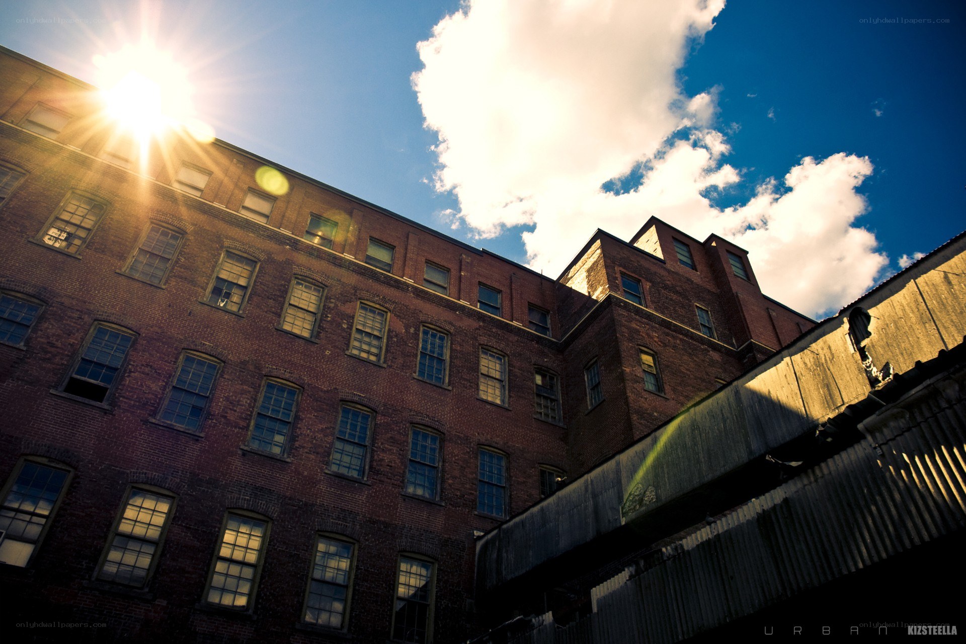 Sunlit brick building with clouds