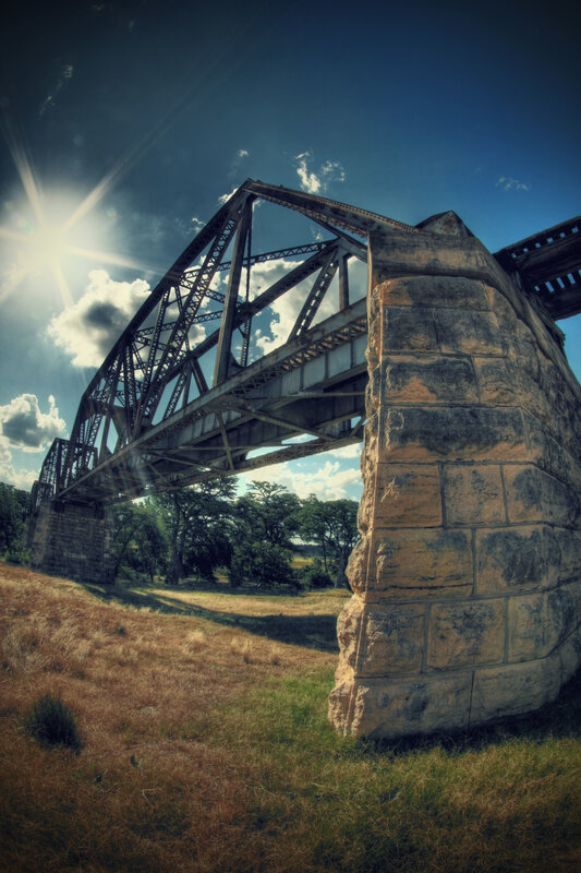 Sunlit bridge over dry grass